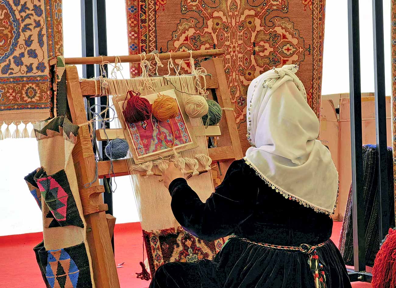 A Woman Weaving a Rug and Rugs.