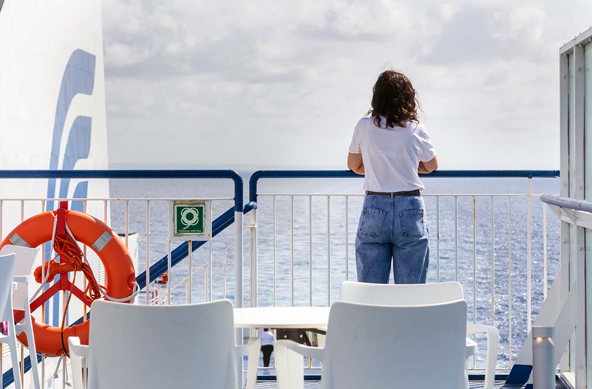 Woman Looking Through a Balcony in a Ferry